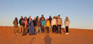 Real traveller photo of group smiling in Sahara desert